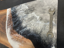 Load image into Gallery viewer, Live Edge Walnut, rich browns and golds, food safe epoxy covering 75% of wood in a  wave pattern white, clear, black and grays with repurposed wrenches.
