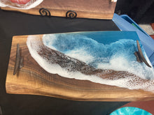 Load image into Gallery viewer, Live Edge Walnut, rich browns and golds, food safe epoxy covering 90% of wood in a wave pattern white, clear, teal blue with boat cleat handles.
