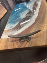 Load image into Gallery viewer, Live Edge Walnut, rich browns and golds, food safe epoxy covering 90% of wood in a wave pattern white, clear, teal blue with boat cleat handles.
