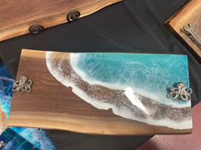 Load image into Gallery viewer, Live Edge Walnut, rich browns and warm golds, food safe epoxy covering 80% of wood in a wave pattern white, clear, teal blue with octopus handles.
