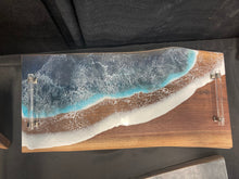 Load image into Gallery viewer, Live Edge Walnut, rich browns and warm golds, food safe epoxy covering 90% of wood in a wave pattern white, clear, light and dark blues with clear tube handles.
